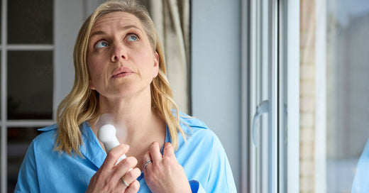 Woman experiencing perimenopause cooling down during hot flash.